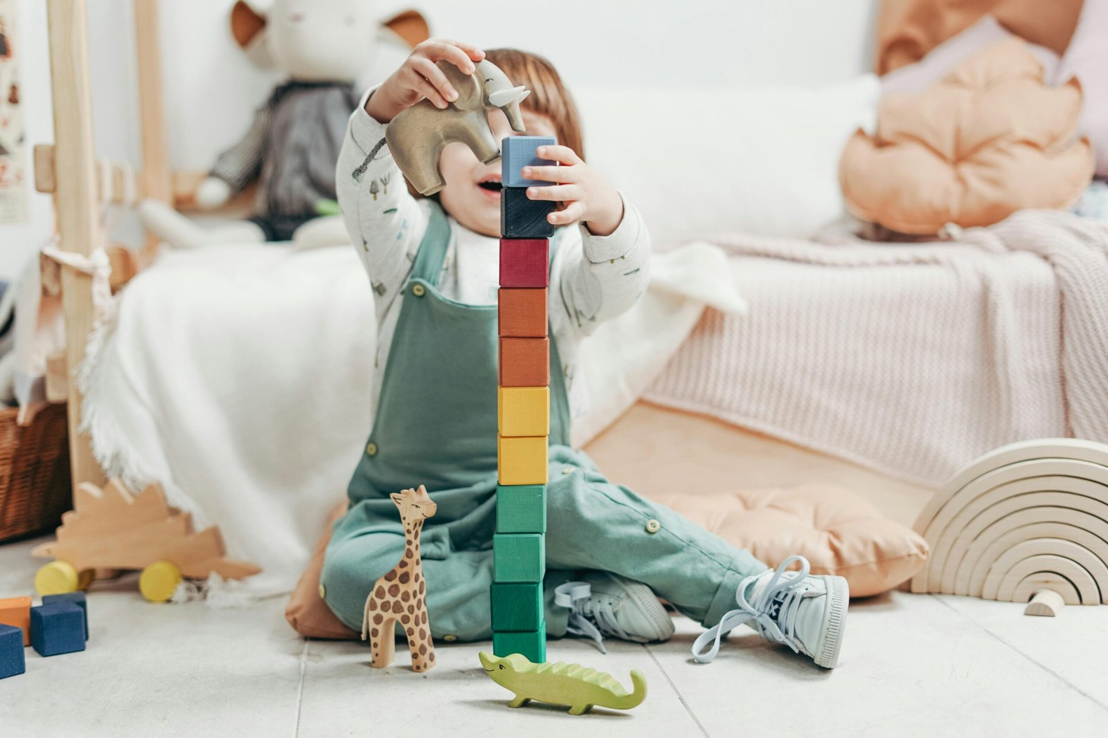 A young child engaged in creative play with colorful wooden blocks indoors.